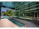 A community swimming pool and hot tub next to a modern building with extensive glass windows at 38 E Serene Ave # 432, Las Vegas, NV 89123