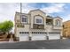 Inviting condo building featuring a stucco exterior, multiple garages, and well-kept landscaping at 3920 Smokey Fog Ave # 201, North Las Vegas, NV 89081