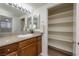 Well-lit bathroom features a vanity with stone countertop and a mirrored closet with ample shelving at 3972 Tirana Way, Las Vegas, NV 89103