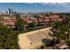 Community tennis court surrounded by lush landscaping near residential buildings and a view of the city skyline at 3972 Tirana Way, Las Vegas, NV 89103