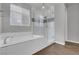 Modern bathroom with a soaking tub, glass-enclosed shower, and white tile at 398 Frank Case Ln, Henderson, NV 89011