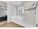 Modern bathroom featuring a soaking tub, glass-enclosed shower, and stylish tile accents at 398 Frank Case Ln, Henderson, NV 89011