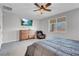 Bright bedroom with a ceiling fan, dresser, and cozy armchair near the window at 398 Frank Case Ln, Henderson, NV 89011