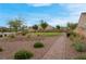 Manicured front yard featuring a paved walkway, desert landscaping, and mature trees for added curb appeal at 398 Frank Case Ln, Henderson, NV 89011