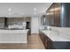 Open kitchen boasts dark cabinets, stainless appliances, and large island with white counters at 398 Frank Case Ln, Henderson, NV 89011