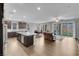 Open-concept living area with kitchen island, dining table, and sliding glass doors to the backyard at 398 Frank Case Ln, Henderson, NV 89011