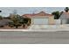 Single-story home with red tile roof, a two-car garage, and a well-kept front yard at 4013 Extenso Dr, North Las Vegas, NV 89032