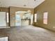 Open-concept living area with carpeted floors, high ceilings, and views into the kitchen at 4013 Extenso Dr, North Las Vegas, NV 89032