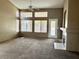 Open living room featuring large windows, a fireplace, and neutral carpet at 4013 Extenso Dr, North Las Vegas, NV 89032