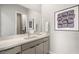 Modern bathroom featuring dual sinks, a large mirror, and a minimalist design with sleek gray cabinetry at 489 Carter House Way, Las Vegas, NV 89138