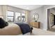 Contemporary bedroom featuring natural light, wooden dresser, and modern mirror at 489 Carter House Way, Las Vegas, NV 89138