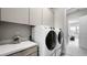 Well-lit laundry room with a side-by-side washer and dryer and ample storage at 489 Carter House Way, Las Vegas, NV 89138