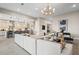 Open-concept living area features modern kitchen, stylish seating, and is illuminated by a contemporary chandelier at 489 Carter House Way, Las Vegas, NV 89138