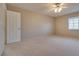 Spacious bedroom featuring neutral carpeting, ceiling fan, and natural light from a window at 500 Quail Bird Pl, Henderson, NV 89052