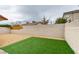 Landscaped backyard featuring a mix of gravel, grass, and concrete block walls for privacy and style at 5151 Tennis Ct, Las Vegas, NV 89120