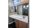 Bathroom featuring a long vanity with a white countertop, wood cabinets and a large mirror at 5217 Yellow Dawn Ct, Las Vegas, NV 89130