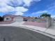 Street view of home showcasing desert landscaping, concrete driveway, and partial brick wall at 5217 Yellow Dawn Ct, Las Vegas, NV 89130