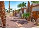 A tropical backyard featuring mature palm trees, decorative rocks, pavers, and gated access at 5401 Indian Hills Ave, Las Vegas, NV 89130