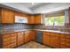 Kitchen features oak cabinets, tile countertops and backsplash, and a window providing natural light at 5401 Indian Hills Ave, Las Vegas, NV 89130