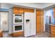 A kitchen featuring wood cabinets, double oven, and a refrigerator with a water dispenser at 5401 Indian Hills Ave, Las Vegas, NV 89130