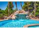 An inviting swimming pool features a custom rock waterfall and landscaping at 5401 Indian Hills Ave, Las Vegas, NV 89130