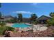 Community outdoor pool surrounded by lush landscaping and seating with nearby residential buildings at 5710 E Tropicana Ave # 1018, Las Vegas, NV 89122