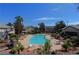 Community outdoor pool surrounded by lush landscaping, seating, and palm trees in a community setting at 5710 E Tropicana Ave # 1018, Las Vegas, NV 89122