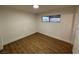 This cozy bedroom includes wood-look floors, a closet, and a window to provide natural light at 5920 Glen Eagles Ln, Las Vegas, NV 89108
