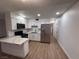 Modern kitchen boasts stainless steel appliances, white cabinetry, quartz countertops and an eat-in island at 5920 Glen Eagles Ln, Las Vegas, NV 89108
