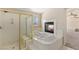 Luxurious bathroom featuring a jetted tub, a fireplace, and a walk-in shower with glass door at 6013 Jubilee Gardens Ave, Las Vegas, NV 89131