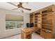 Comfortable office space with built-in shelves, a large desk, and a bright window overlooking the yard at 6013 Jubilee Gardens Ave, Las Vegas, NV 89131