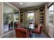 Bright dining area features hardwood floors, built-in shelving and cabinets, plus glass table and seating for four at 606 Cadence Vista Dr, Henderson, NV 89011