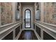 Elegant hallway with decorative mirrors, patterned wallpaper, detailed molding, and hardwood floors at 606 Cadence Vista Dr, Henderson, NV 89011