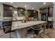 Spacious kitchen island features granite countertops, dark cabinets, stainless appliances, and counter seating at 606 Cadence Vista Dr, Henderson, NV 89011