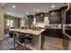 Modern kitchen with granite countertops, dark cabinetry, stainless steel appliances, and an island with seating at 606 Cadence Vista Dr, Henderson, NV 89011