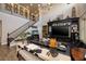 Spacious living room with a grand staircase, high ceilings, custom shelving, and stylish decor at 606 Cadence Vista Dr, Henderson, NV 89011