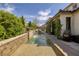 Outdoor pool with a tiled waterfall feature, complemented by lush greenery, and the building's architectural details at 606 Cadence Vista Dr, Henderson, NV 89011