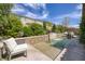 Residential pool featuring a tiled waterfall feature, surrounded by landscaping, and patio seating area at 606 Cadence Vista Dr, Henderson, NV 89011