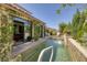 Backyard pool with a waterfall feature, well-maintained landscaping, and patio area accessible through glass doors at 606 Cadence Vista Dr, Henderson, NV 89011