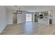 Open-concept living room and kitchen area featuring wood floors, modern light fixture and backyard access at 6100 Fawn Cir, Las Vegas, NV 89107