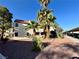 An exterior shot of the apartment complex with desert landscaping, palm trees and a two-story stucco building at 6137 W Oakey Blvd # A, Las Vegas, NV 89146