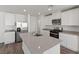 Modern kitchen featuring white cabinets, stainless steel appliances, and a center island with quartz countertops at 6787 Magnolia River Ave, Las Vegas, NV 89156