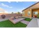 Charming backyard featuring a fire pit with seating, a well-maintained lawn, and lush greenery at 6980 W Meranto Ave, Las Vegas, NV 89178