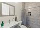Stylish bathroom featuring gray wall tile, a glass shower, and a framed mirror above the sink at 6980 W Meranto Ave, Las Vegas, NV 89178