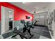 Finished garage with a red accent wall, gym equipment, and a mounted TV for convenience at 6980 W Meranto Ave, Las Vegas, NV 89178