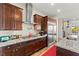 Well-equipped kitchen with granite countertops, gas range, stainless steel appliances, and cherry wood cabinets at 6980 W Meranto Ave, Las Vegas, NV 89178
