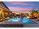 Backyard pool and spa with fire pit, covered outdoor dining area, and beautiful sunset sky at 6980 W Meranto Ave, Las Vegas, NV 89178