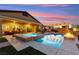 Backyard pool and spa with a built-in fire pit and outdoor dining area at sunset at 6980 W Meranto Ave, Las Vegas, NV 89178