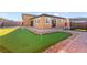 Backyard putting green is surrounded by desert landscaping and pavers; ideal for leisurely outdoor recreation at 6980 W Meranto Ave, Las Vegas, NV 89178