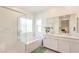 Elegant bathroom featuring double sinks, a soaking tub, and glass enclosed shower at 7045 Judith River St, North Las Vegas, NV 89084